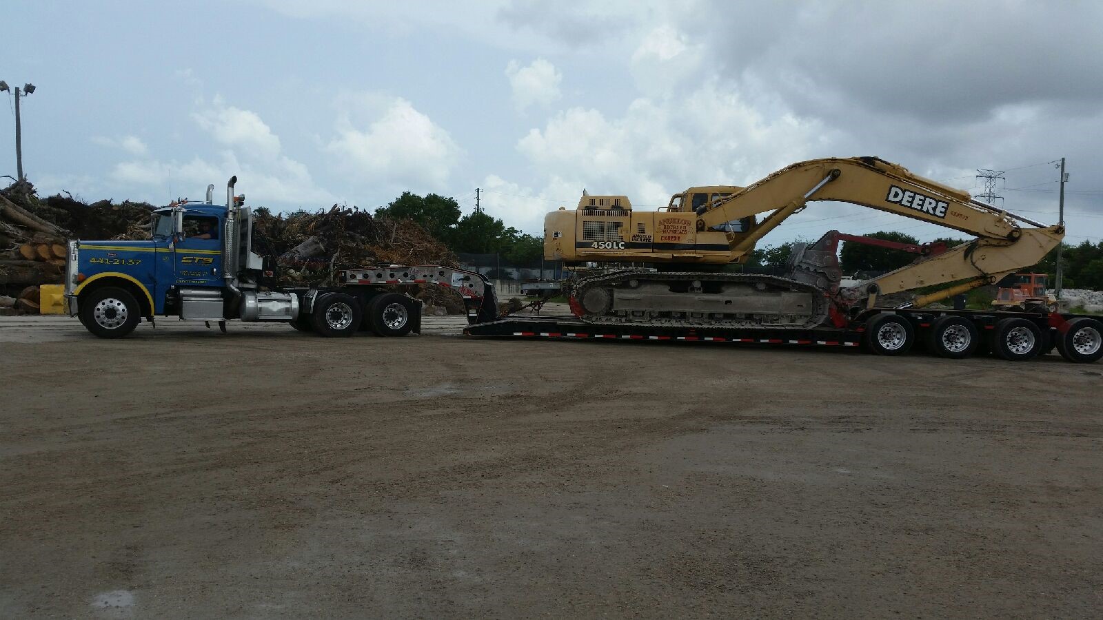 Lowboy excavator being towed by CTS Tow truck